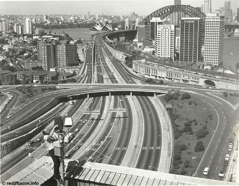Kevin Hands, seen here making precarious adjustments to one of the camera units.  Sydney Harbour Bridge.  1972